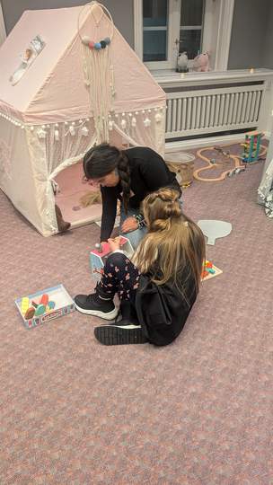 Kinder spielen mit Gesellschaftsspielen, Rollenspielen und Kuscheltieren bei der Weihnachtsfeier
