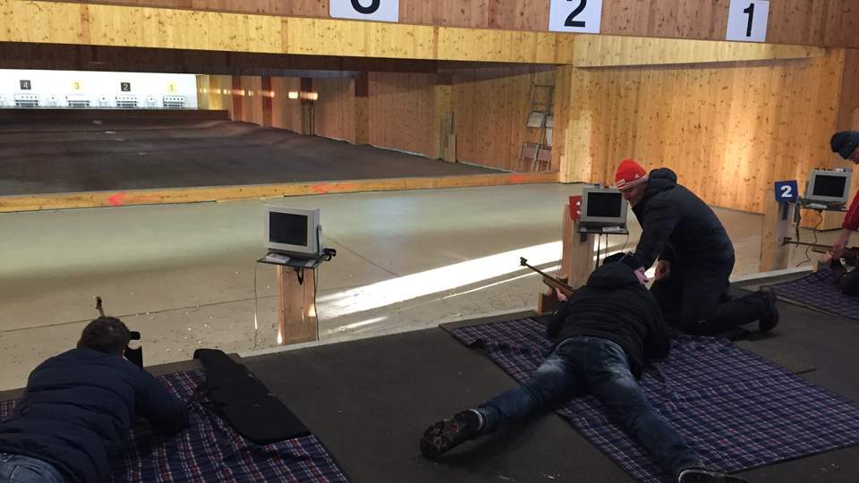 Schießübungen am Schießstand Oberhof Zwei Menschen schießen liegend auf Zielscheiben. Sven Fischer erklärt etwas.