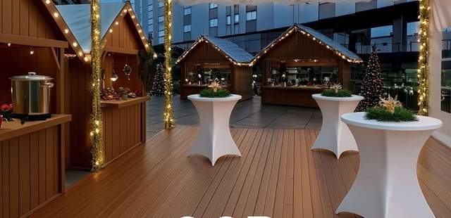 Weihnachtlich geschmücktes Zelt mit Stehtischen und Weihnachtsmarkthütten und dem Schriftzug "GOP Weihnachtsmarkt".