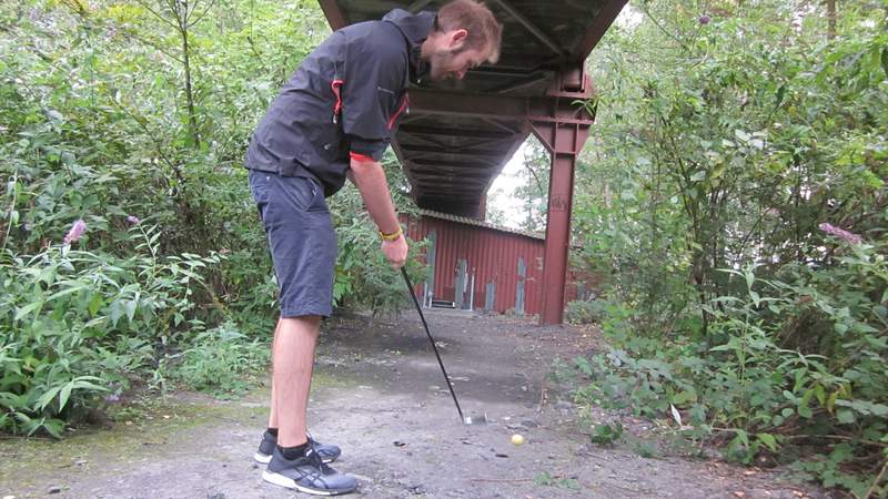 Eine Person versucht den Golfball zu schießen