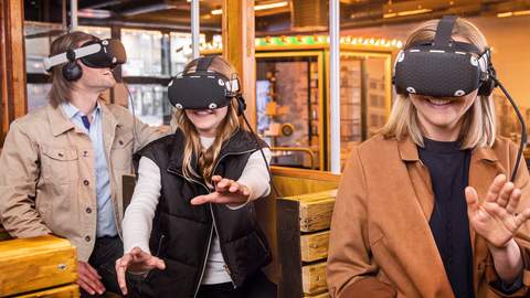 Menschen mit VR-Brille im Nachbau einer alten Tram