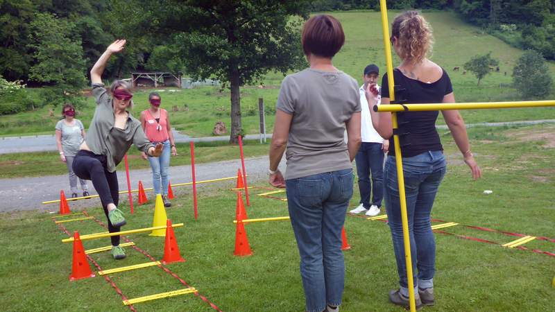 Drei Frauen im Hindernisparcours mit Augenmaske beim Teamtraining Dream-Team