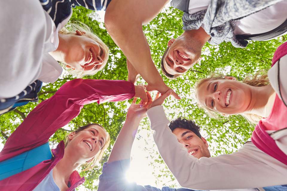 Team Event für Azubis Junge Leute geben High Five in geselliger Runde