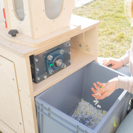 Aus der Plastikpreneur Maschine kommt geschreddertes Plastik heraus und wird aufgefangen