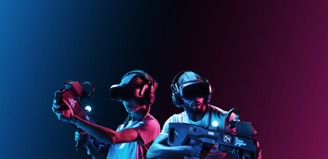 Zero Latency Hannover Eine Frau und ein Mann tragen Virtual Reality Brillen und Gewehrcontroller und sehen konzentriert aus.