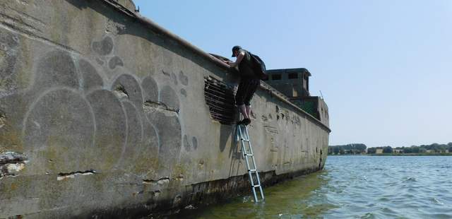 Schiffswrack in der Ostsee. Ein Mann klettert an Bord Ostsee - Kanutour + Picknick auf Schiffswrack