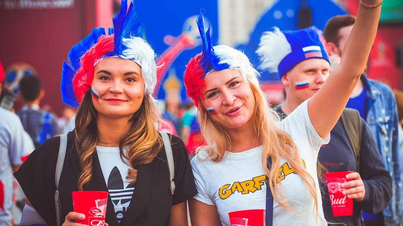 Zwei lachende russische Damen mit blau-rot-weiß gefärbten Haaren