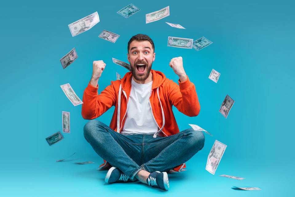 Bonus Incentive als Geldprämie Mann sitzend, freut sich über Geld