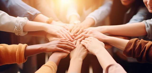 Die ultimative Checkliste zum JGA planen Eine Team steht lächelnd im Kreis und legt die Hände in der Mitte zusammen