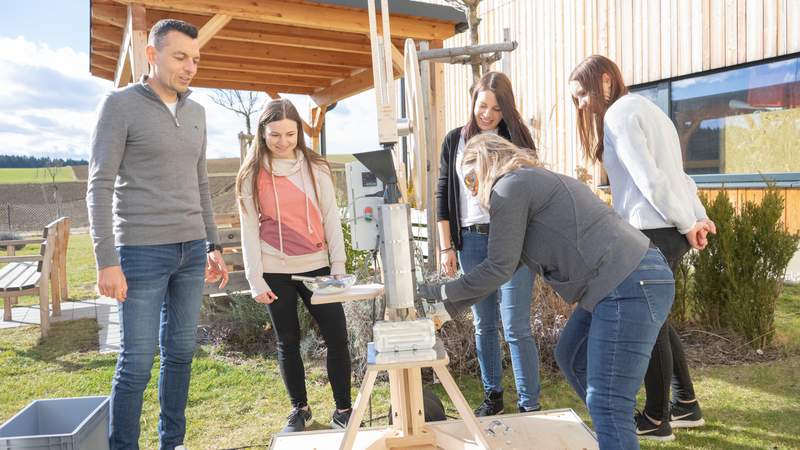 Personen bedienen gemeinsam den Plasticpreneur Extrudor