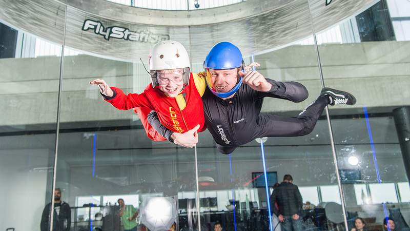 Kinder, die im Windkanal fliegen