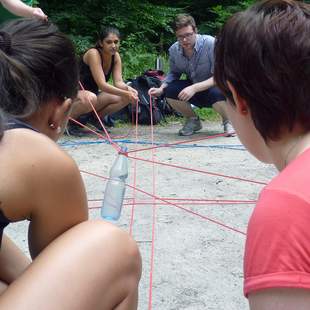 Zwei Frauen bei Teamaktion mit Schnüren beim Teambuilding Dream-Team