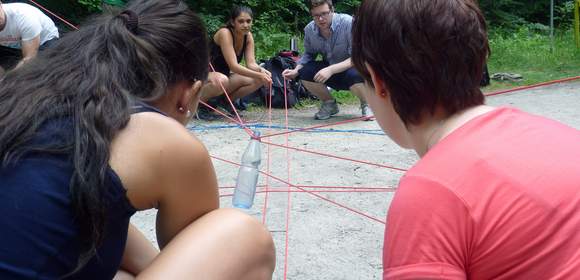 Zwei Frauen bei Teamaktion mit Schnüren beim Teambuilding Dream-Team