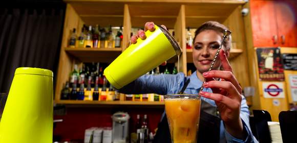 Eine Frau mixt leckere Cocktails