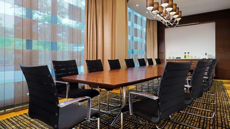 Konferenzraum mit einem braunen Tisch und schwarzen Stühlen