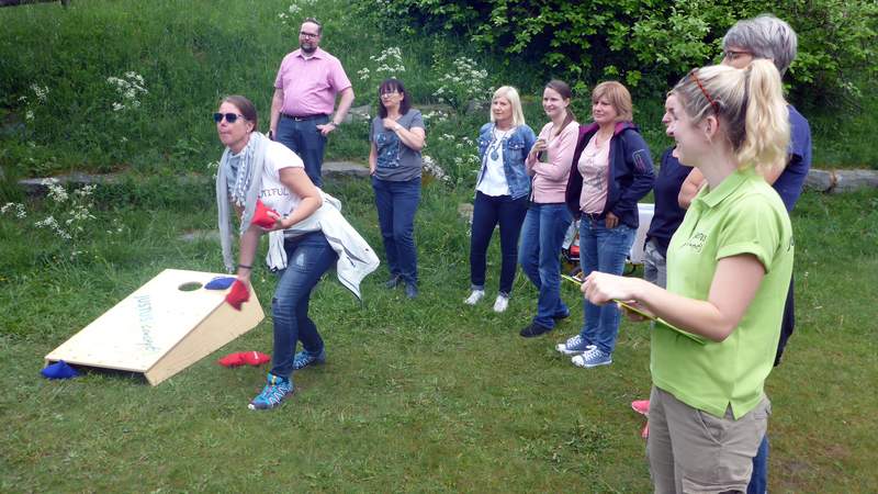 Frau wirft beim Cornhole als ein Programmteil von Fun Golf