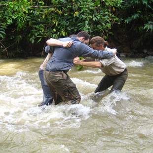 Teilnehmer der Wildnisschule Wurzelholz stehen im Wasser