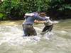 Teilnehmer der Wildnisschule Wurzelholz stehen im Wasser