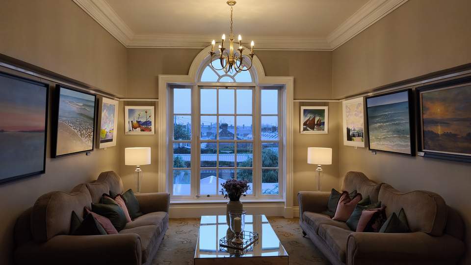 Gemütlicher Sitzplatz mit 2 Couchen und einem großem Fenster mit Ausblick auf die Natur im Hotel Hayfield Manor in Cork