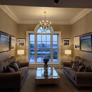Gemütlicher Sitzplatz mit 2 Couchen und einem großem Fenster mit Ausblick auf die Natur im Hotel Hayfield Manor in Cork