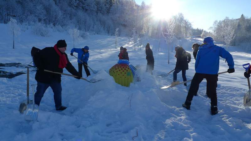 Die Teammitglieder bauen gemeinsam ein Iglu.