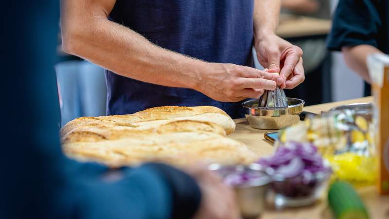 Teilnehmer presst frischen Zitronensaft während des interaktiven Kochworkshops von Mundet-App