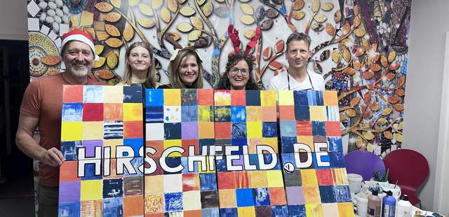 Das Hirschfeld-Team mit dem fertigen Kunstwerk Puzzle Painting: Kreative Weihnachtsfeiern